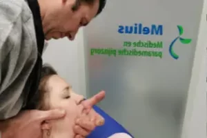 De therapeut voert mobilisatietechniek uit bij nekklachten door gebruik te maken van manuele therapie.