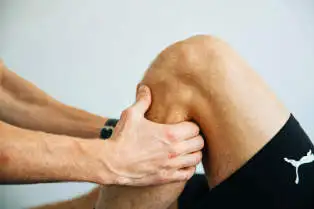 Fysiotherapeut behandelt de knie van een patiënt als onderdeel van een gerichte fysiotherapie zonder wachttijd.