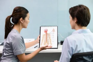 Zorgprofessional legt oefeningen of pijnmechanismen uit tijdens pijnrevalidatie.